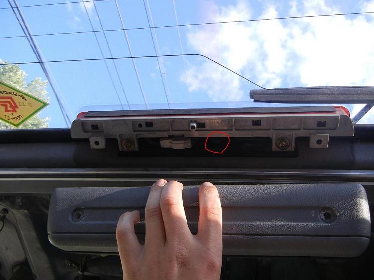 Light cover removed with door lock knob circled. The plastic rivets holding will probably need to be broken but any parts store will sell ones that fit.