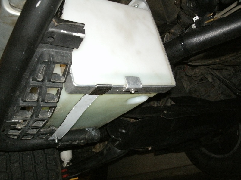 A little overkill on the straps, but I seem to have an abundance of aluminum and stainless around.  Note the use of the step mounting bolt for the strap anchor.  The tank &quot;rests&quot; on the rear of the step.
