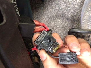 Another angle. You can see how melted it is and the red wire that plugs into a black cube thing.