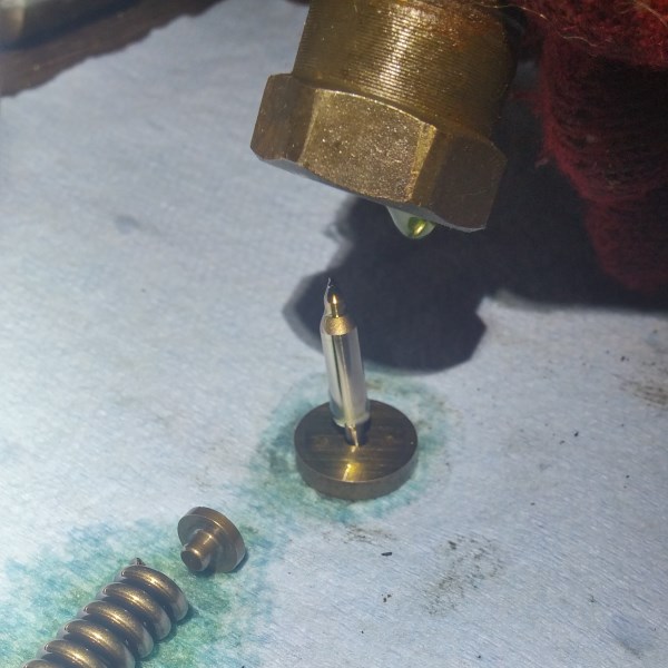 To drop the pintle and seat, gently tap the injector body on a clean surface and the pintle and seat will drop out.