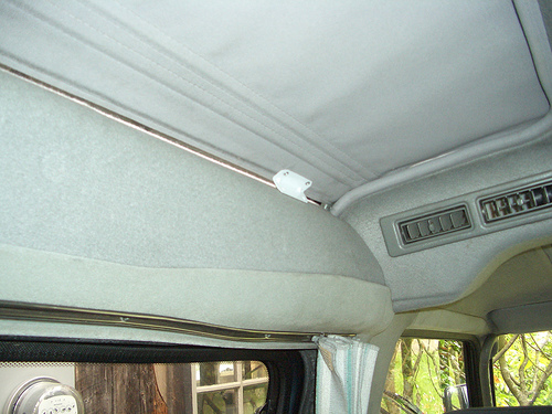 small metal bracket pop riveted to blind holds closed with rare earth magnets