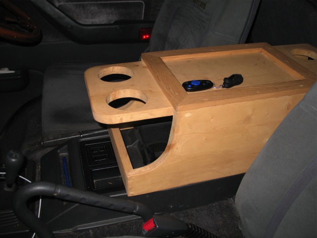 Cupholders on the forward edge, open compartment underneath. Essentially took the Mitsubishi console lid off, place my console over top.