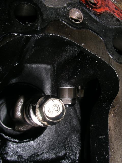The balance shaft stick out (metric bolt labeled with the grading number of &quot;10&quot;) and in the background behind it is the nozzle for the piston squirter that is mounted via a banjo bolt to the oil gallery...