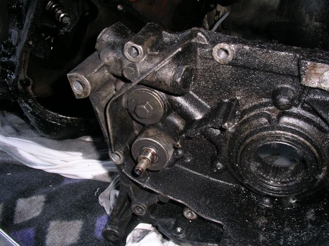 The front side of the same cover. The pulley that the balance shaft/oil pump is driven by has been removed and you can see the shaft stickout.