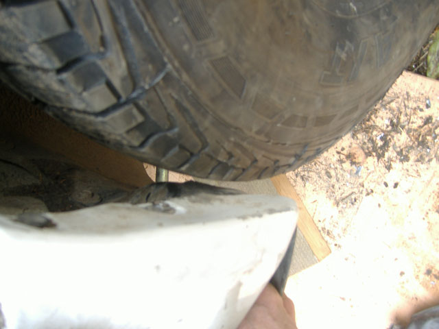 with tire back on. there is actually more space then it looks because the mud flap is still molded to that position.