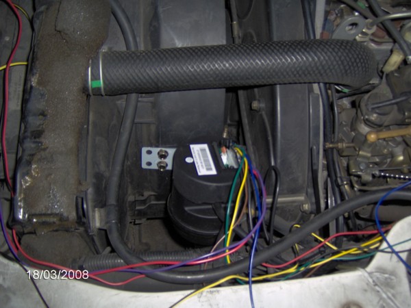 Here is the servo mounted to the side of the fan shroud.  vacuum hose goes under the rad hose and across the the other side.  Controller wires go back and up under the console.  Power wires go forward and up between the two shifters then under the carpet to the dash.  Speed sensor wire go down and is tied to places where it will stay protected.